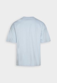 Svetle modré tričko s krátkým rukávem a kulatým výstřihem, vyrobené z měkké bavlněné směsi, s volným střihem a minimalistickým designem.