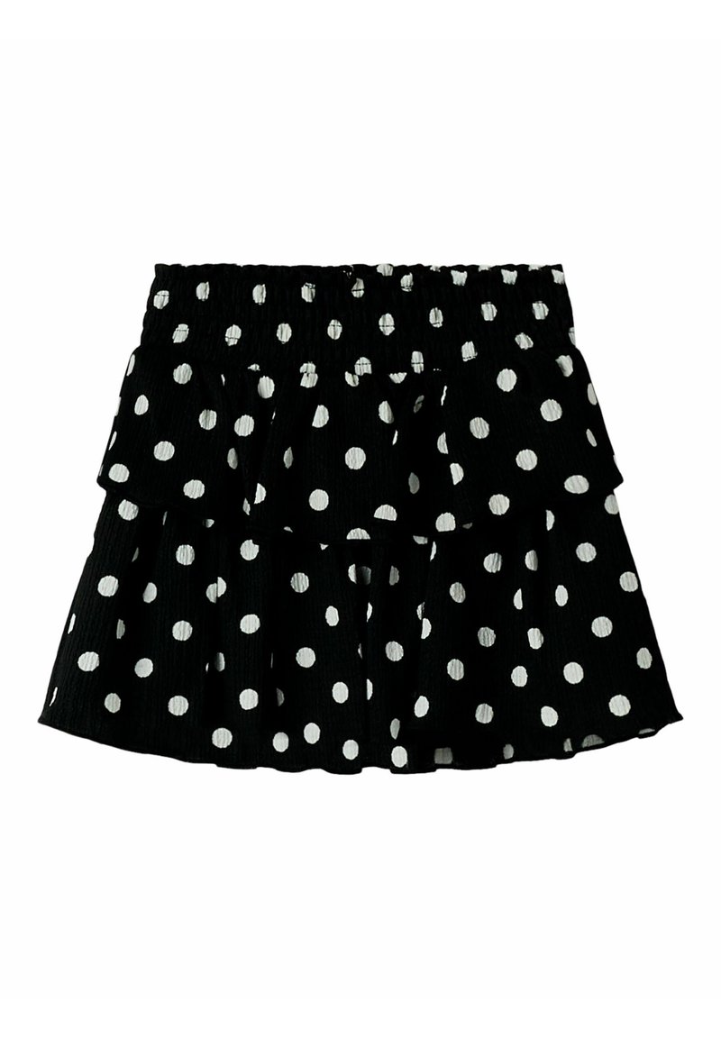 Zwarte rok met stippen in een gelaagd ruches ontwerp; heeft een elastische tailleband en witte cirkelvormige patronen die gelijkmatig verspreid zijn.