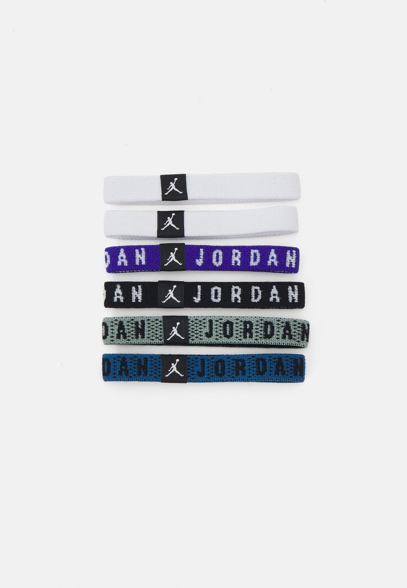 Cinq élastiques à cheveux de couleurs variées : blanc, violet, noir, vert clair et bleu marine, chacun avec une étiquette de logo noire affichant "JORDAN."