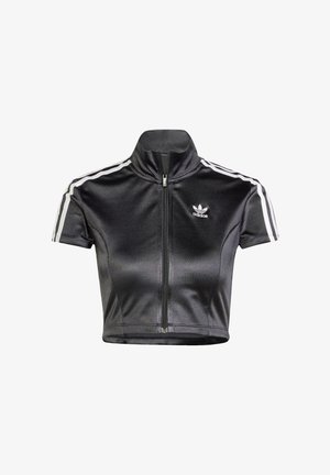Chaqueta negra corta con cremallera frontal, cuello alto, mangas cortas y franjas laterales blancas. Presenta un logo bordado en el pecho.