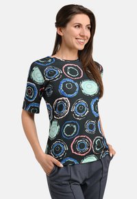 Short-sleeve black top featuring a colorful circular pattern in blue, pink, and green. Made of smooth fabric with a round neckline.