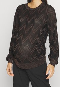 Maglione nero con motivo a zigzag metallizzato, maniche lunghe e polsini a coste. Realizzato in un tessuto leggero e luminoso.