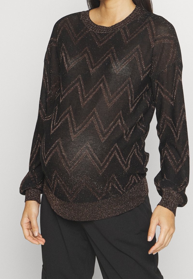 Maglione nero con motivo a zigzag metallizzato, maniche lunghe e polsini a coste. Realizzato in un tessuto leggero e luminoso.