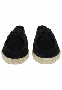 Zapatos negros de ante tipo slip-on con suelas de yute trenzado, que presentan una puntera redondeada y un sutil detalle de cordones en la parte superior.