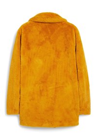 Cappotto in pelliccia sintetica giallo brillante, con una superficie morbida e texturizzata, colletto a punta e maniche lunghe. La vista posteriore mostra una vestibilità comoda.