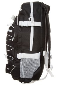 Mochila negra de nailon con cremalleras y correas blancas, que cuenta con un bolsillo de malla, hebillas ajustables y cuerdas elásticas para almacenamiento adicional.