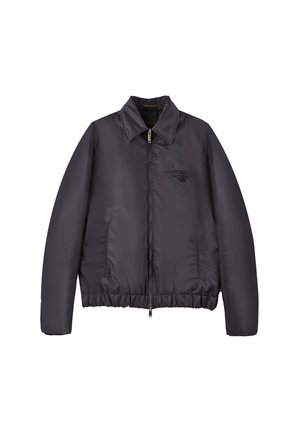 Chaqueta acolchada negra con cierre de cremallera, cuello alto, dobladillo elástico y un bolsillo en el pecho. Fabricada con un tejido suave y ligero con un diseño elegante.