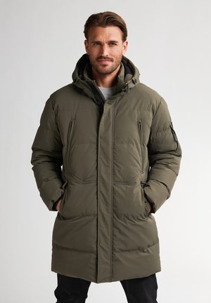 Manteau rembourré vert olive avec capuche, doté de deux poches zippées à l'avant et d'un design texturé et matelassé. Accents noirs sur les manches.