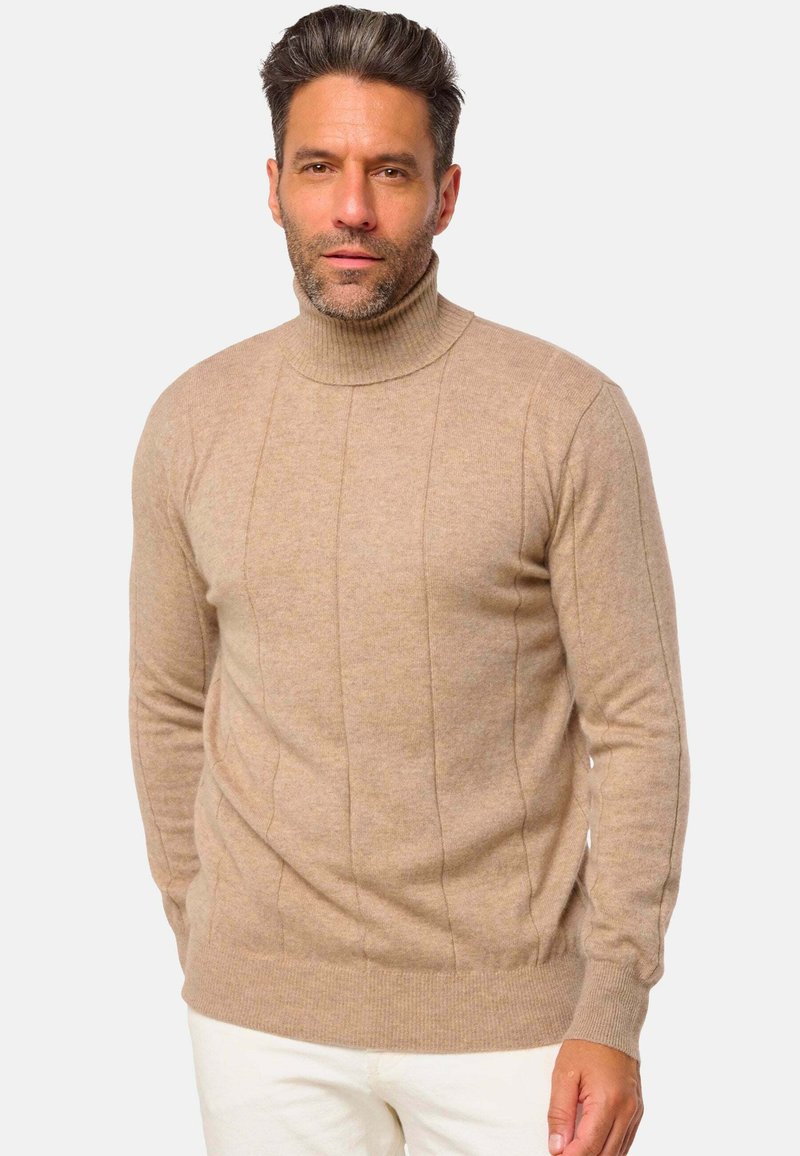 Pull col roulé beige en doux tricot, avec des poignets et un ourlet côtelés, et des détails de panneaux verticaux sur le devant.