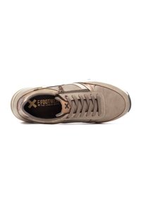 Zapatilla beige con materiales de ante y sintéticos. Presenta cordones planos, acentos cosidos y una suela texturizada. Marca visible en el interior.