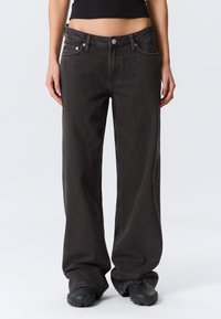 Weit geschnittene, dunkelgraue Jeans aus Denim mit fünf Taschen, kupferfarbenen Beschlägen und glatter Textur.