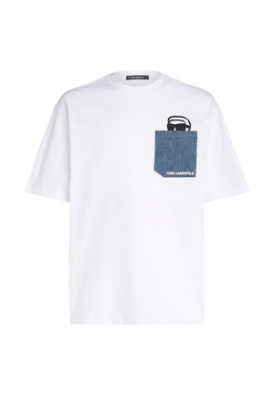 T-shirt bianca in cotone con taschino in denim, decorata con una grafica di occhiali da sole neri e il testo "KARL LAGERFELD" in bianco. Collo rotondo e maniche corte.