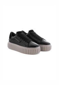 Zwarte leren sneakers met een robuuste lichtgrijze zool. Voorzien van platte veters en een gladde bovenkant met subtiele branding aan de zijkant.