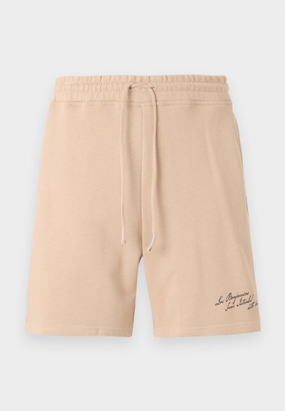 Shorts en coton beige avec une taille élastique munie d'un cordon de serrage et un détail décoratif brodé sur la partie inférieure de la jambe gauche.