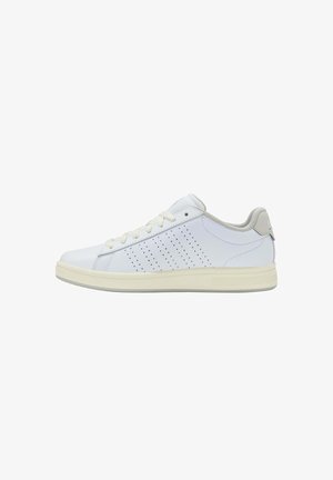 Zapatilla baja blanca con franjas perforadas en los lados, suela beige, cordones blancos y cuello acolchado gris claro, mostrada en perfil derecho.