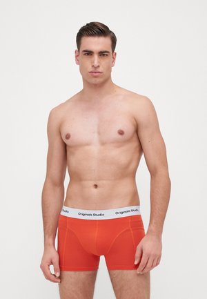 Herren-Boxershorts in leuchtendem Orange, aus Baumwollmaterial. Mit einem weißen Bund, auf dem "Originals Studio" steht. Glatte Textur mit figuraler Passform.