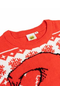 Maglione rosso lavorato a maglia con un motivo di fiocchi di neve bianchi e neri e un design di personaggio dei cartoni animati sul davanti. Include un'etichetta.