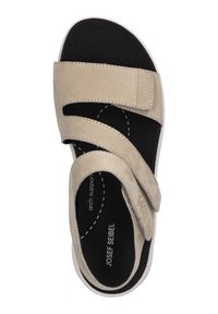 Sandal in suede beige con due cinturini in velcro, soletta nera sagomata e suola in gomma bianca. Presenta supporto per l'arco plantare e un design snello.