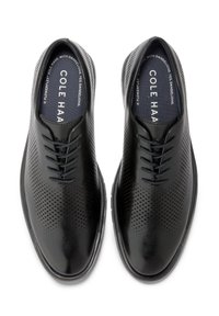 Scarpe da uomo in pelle nera con design perforato, chiusura con lacci e finitura liscia. Suola resistente realizzata in tarassaco.