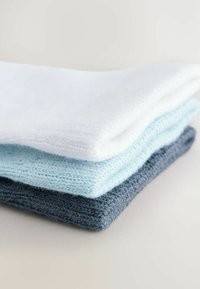 Trois tissus empilés : le haut en blanc, le milieu en bleu clair, le bas en bleu foncé ; tous présentent un tissage doux et texturé avec des contrastes de couleurs subtils.
