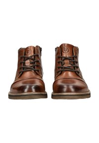 Botas de cuero marrón hasta el tobillo con punta redondeada, cordones texturizados y costuras decorativas. Suela de goma con un patrón de banda de rodadura mínimo.