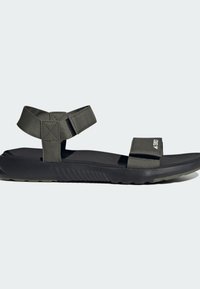 Mørk grå sandaler med myk gummisåle, strukturert fotbed og justerbare nylonstropper. Har borrelås for en sikker passform.