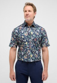 Camicia a maniche corte realizzata in tessuto con sfondo blu navy e un vivace motivo floreale in vari colori e texture.
