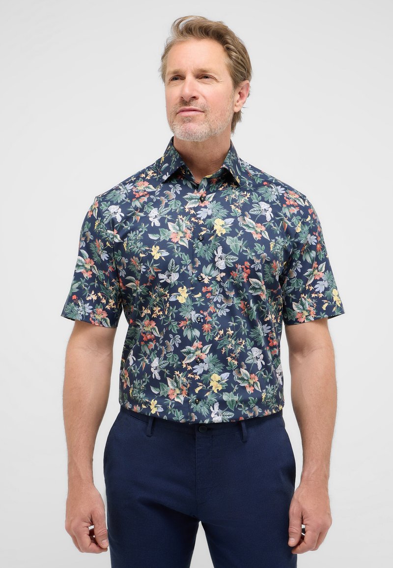 Camicia a maniche corte realizzata in tessuto con sfondo blu navy e un vivace motivo floreale in vari colori e texture.