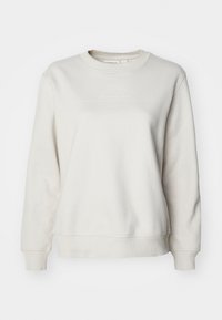 Lys beige sweatshirt laget av mykt stoff, med rund hals, lange ermer, ribbestrikkete mansjetter og en subtil merkevarelogo over brystet.