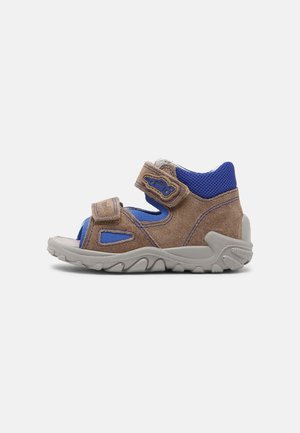 Børns brune og blå sandal med åbne tæer, justerbare stropper og en holdbar grå sål designet til udendørs brug.