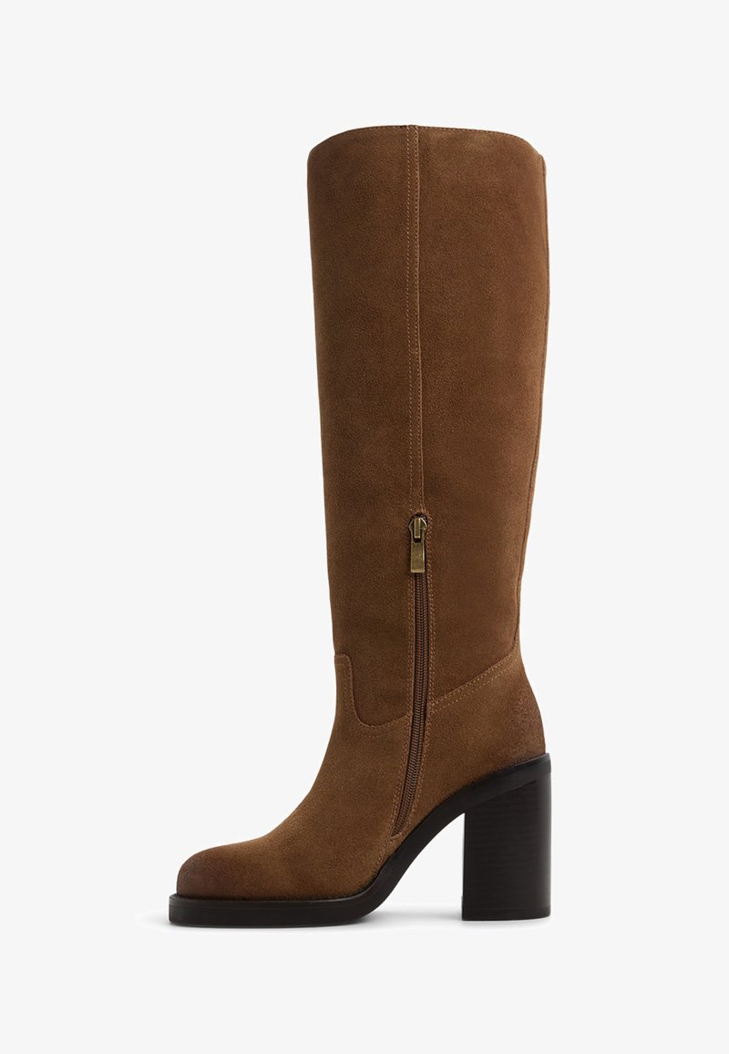 Stivale alto in suede marrone con punta tonda, zip laterale e tacco spesso. Texture liscia con un design semplice e accenti minimi.