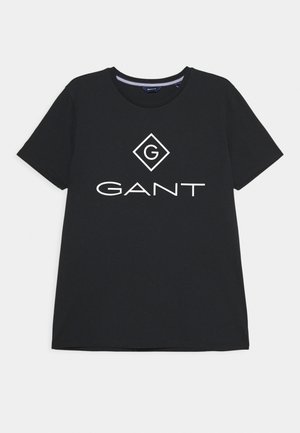 T-shirt in cotone nero con scollo rotondo, caratterizzato da un logo GANT bianco e un design a forma di diamante ben visibile al centro.