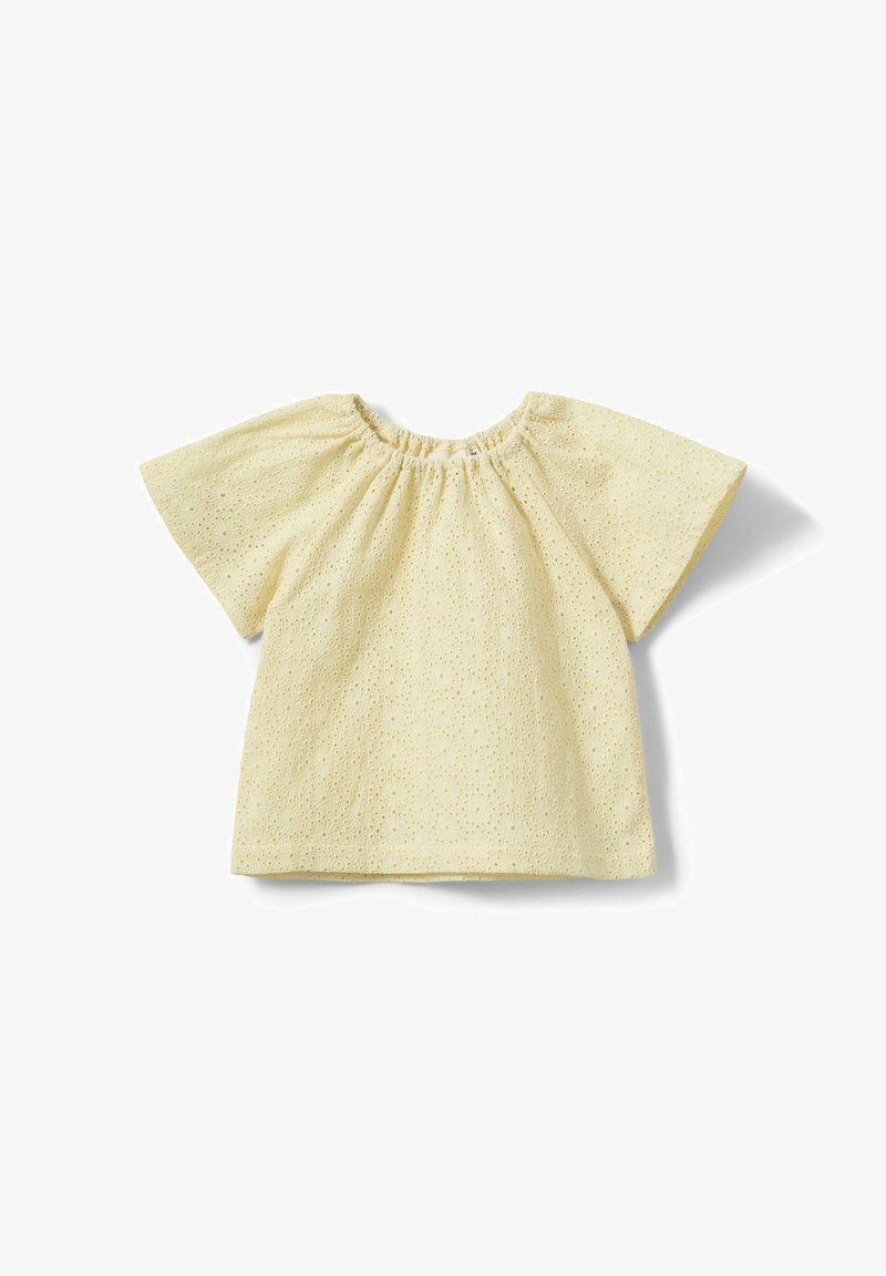 Blouse courte à manches courtes jaune crème avec encolure ronde élastiquée et motif brodé floral à œillets sur le tissu.