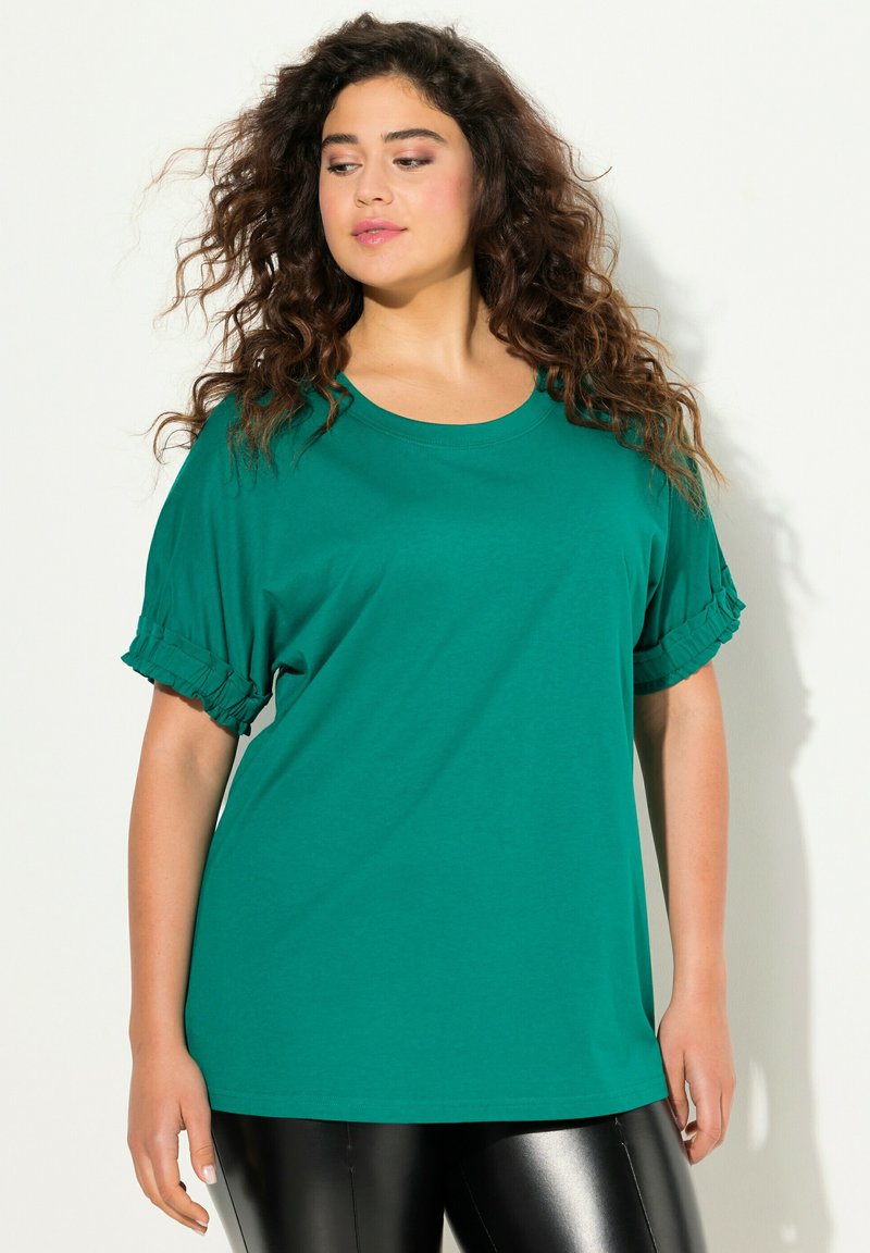 T-shirt teal oversize con maniche corte e arricciate. Realizzato in tessuto morbido, presenta un collo rotondo e una vestibilità comoda.