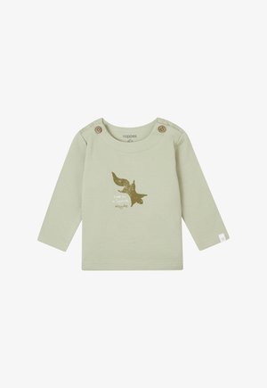 Chemise à manches longues vert clair en coton. Présente des boutons en bois à l'épaule et un graphique d'écureuil doré avec du texte en dessous.