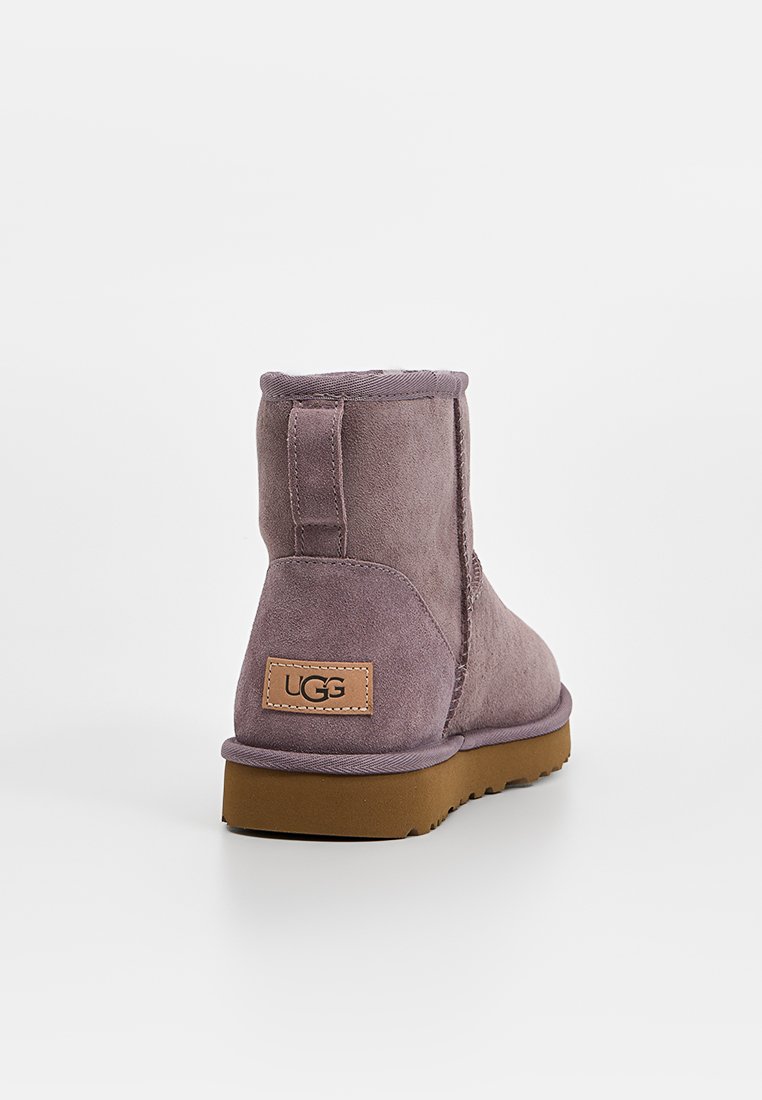 Stivale alla caviglia in suede viola con finitura texture, suola in gomma e un'etichetta in pelle con logo sul retro. Fodera liscia e apertura elastica.