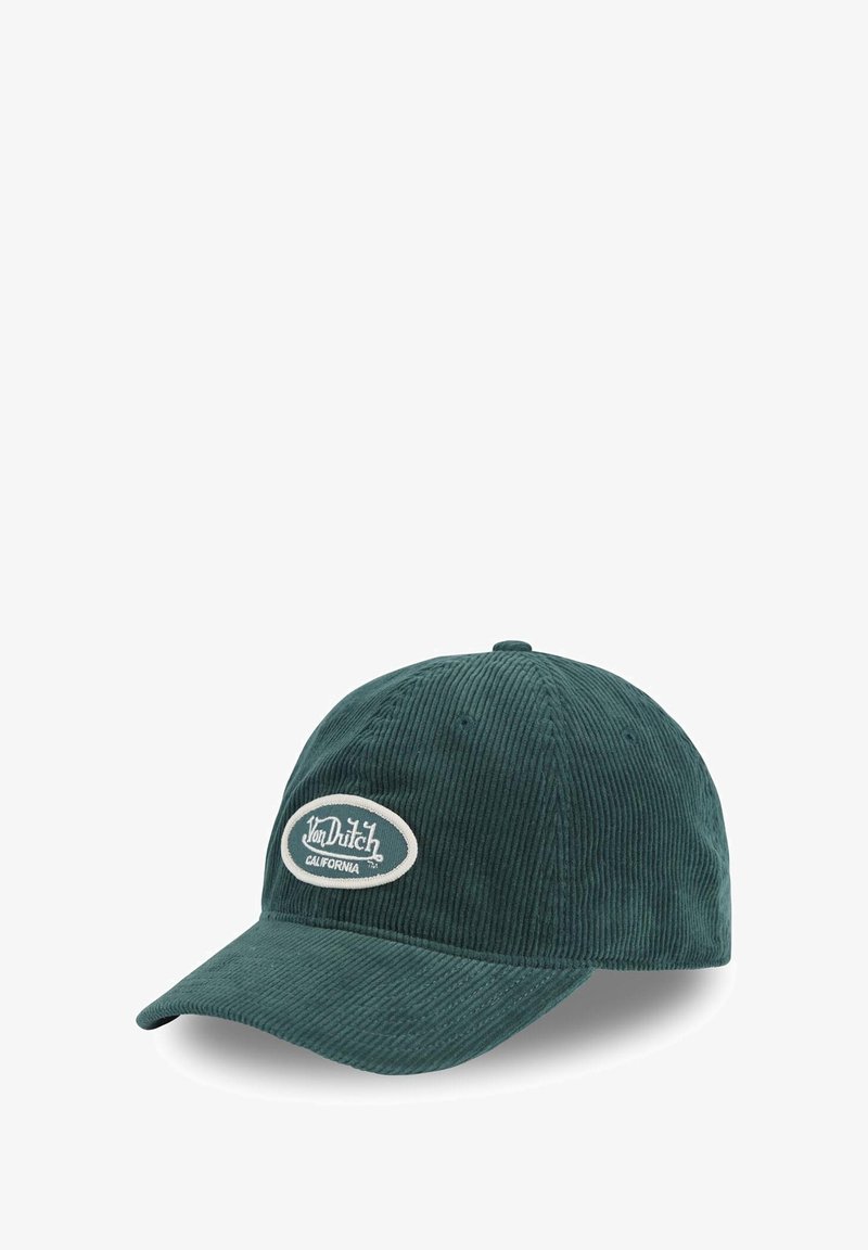 Casquette en velours côtelé vert avec une visière incurvée, ornée d'un logo brodé sur un patch ovale blanc. Tissu texturé et détails de couture visibles.