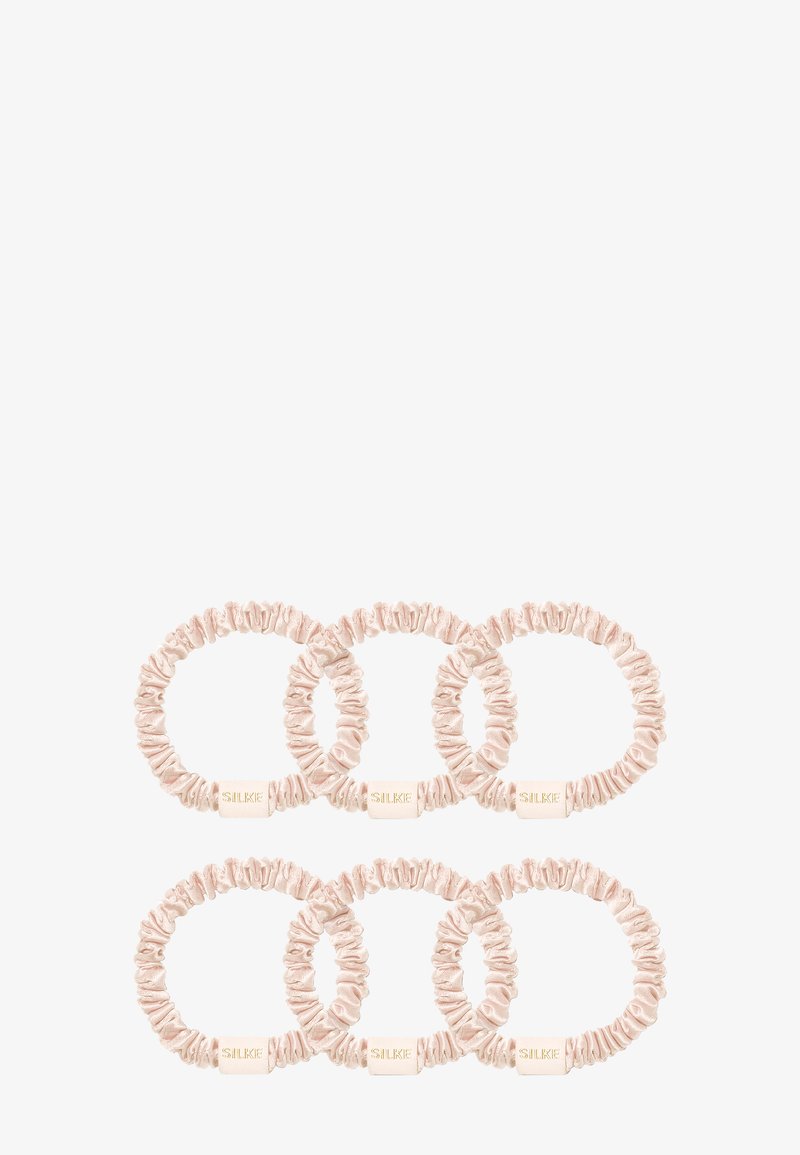 Viisi hiuslenkkiä, jotka on valmistettu pehmeästä, vaaleanpunaisesta satiinikankaasta. Ne sisältävät kerättyä tekstuuria, pyöreän muodon ja jokaisessa on pieni brändilapku.