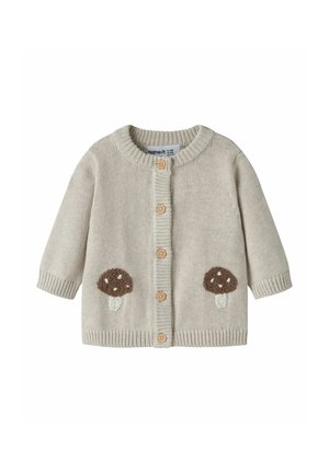 Cardigan bébé beige en maille avec col rond, boutons en bois sur le devant, et patches marron en forme de champignon de chaque côté près de l'ourlet.