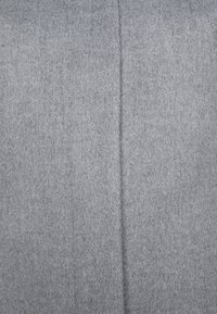 Tissu gris lisse avec une couture verticale au centre, montrant une texture douce semblable au feutre.