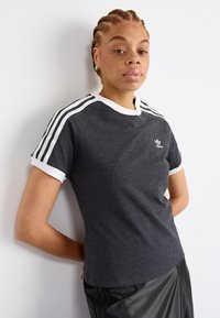 Grijze sport t-shirt met witte kraag en mouwboorden, voorzien van drie witte strepen op elke schouder en een geborduurd logo op de borst.