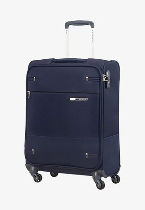 Valigia blu navy con esterno in tessuto testurizzato, quattro ruote, manico estensibile e tasca frontale con zip. Presenta elementi di branding e dettagli in metallo.