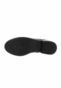 Suela de un zapato de cuero marrón con una banda de goma negra que presenta patrones geométricos y un área rectangular hundida cerca del talón.