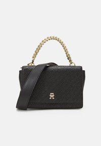 Schwarze Lederhandtasche mit einem goldenen Kettenhenkel und einem verstellbaren schwarzen Träger, mit einem geprägten geometrischen Muster und einem goldenen Logoakzent.