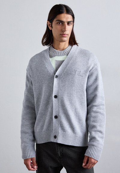 Grau kardigan aus weichem Strickstoff, mit V-Ausschnitt, fünf Knöpfen, gerippten Bündchen und einem dezenten Logo auf der Brust. Über einem gemusterten Pullover getragen.