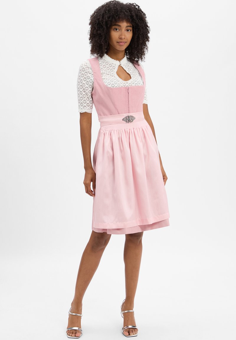 Rosa Dirndl mit tailliertem Oberteil, weißer Spitzenbluse, Schlüssellochausschnitt und plissiertem Rock. Verziert mit dekorativen silbernen Akzenten.