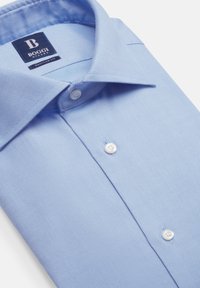 Jasnoniebieska koszula z guzikiem, wykonana z teksturowanej tkaniny. Posiada klasyczny kołnierzyk, białe guziki oraz metkę identyfikującą markę Boggi.