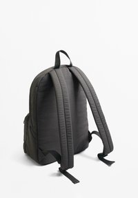 Sac à dos noir rembourré avec une texture lisse, des bretelles épaisses, des poches latérales et des bretelles réglables. Design compact avec une forme arrondie.