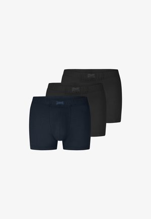 Tre par tætsiddende herreboxershorts i mørk marineblå og sort, stablet i et trappemønster på en hvid baggrund.