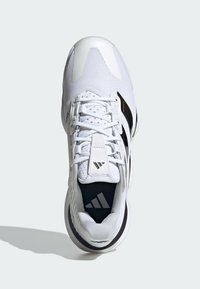 Weiße Sportschuh mit einem Obermaterial aus Mesh, Schnürverschluss und schwarzen Akzenten. Verfügt über eine strukturierte Sohle und ein auffälliges Markenlogo auf der Zunge.